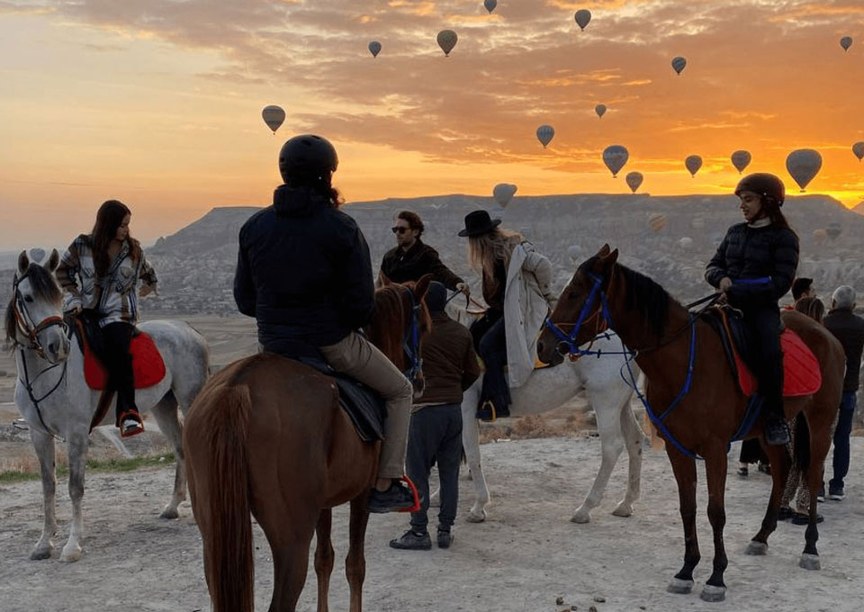 Riders passing fairy chimneys on horseback